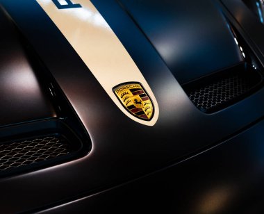 Arabanın kaputuna yakın plan Porsche logosu..