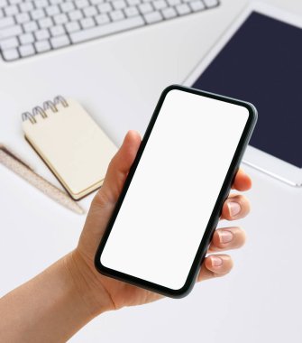 Model mobil uygulama dijital düzenleyici. El ele tutuşan telefon, günlüğün önünde boş ekran, dijital tablet ve masanın üzerinde bilgisayar..