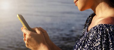 Yazın güneşli bir günde telefon kullanan bir kadın.. 