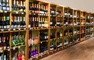 Farklı şarap şişeleri ve seçici odaklı büyük perakende rafları. İçki dükkanı ve şarap üretim endüstrisi için pankart.