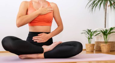 Nefes egzersizi. Yoga meditasyon egzersizi. Yoga Lotus pozisyonunda bir kadın egzersiz minderinde.