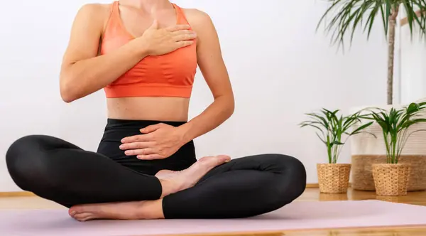 Breathing exercise. Yoga meditation exercise. Woman in yoga lotus position on exercise mat.