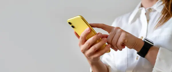 İş kadını akıllı telefonuyla internetten mesajlaşıyor. Kadın parmağınla ekranına dokunuyor..