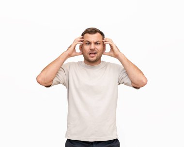 Nonplussed adult man expressing emotions of confusion on white background in studio.