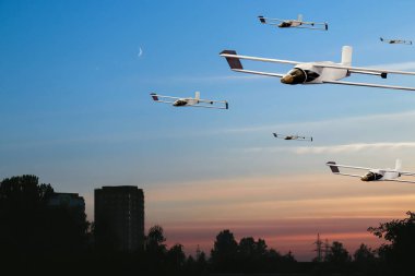 Hava bombalı askeri hava araçları şehrin üzerinde akşam gökyüzünün arka planında uçuyor..
