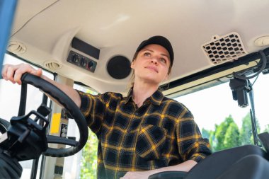 Beyaz kadın ekose gömlek giyiyor ve inşaat makineleri kullanıyor.