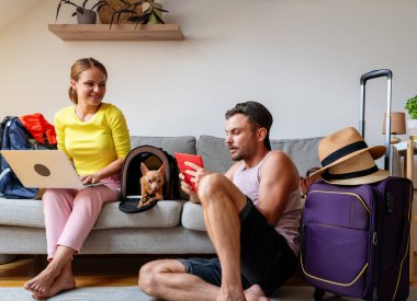 Yolculuk öncesi hazırlık. Laptop ve pasaport bilgileriyle seyahat eden genç çift.