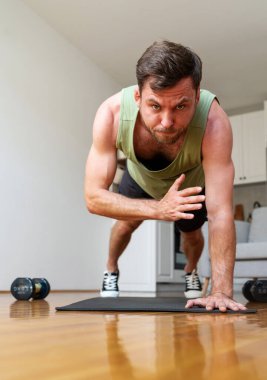 Adam evde omuz vuruşu egzersizi yapıyor. Sağlıklı ve sportif yaşam tarzı.