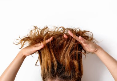 Saç problemleri. Kuru, hasarlı saçlarını gösteren bir kadın..