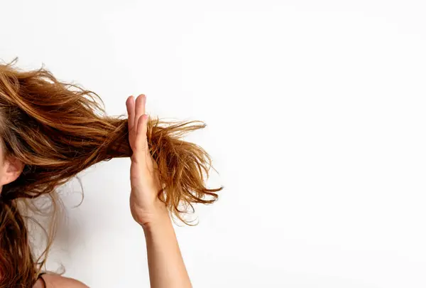 Saç problemleri. Kuru, hasarlı saçlarını gösteren bir kadın. Saçlar elinde..