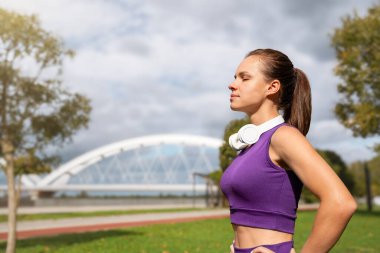 Şehirdeki bir spor sırasında nefes egzersizi yapan sportif bir kadın..