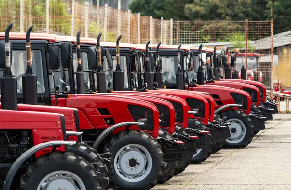 Tarımsal ekipman bayiliği geçmişi. Farklı kırmızı renkli çiftlik traktörleri çizgisi.