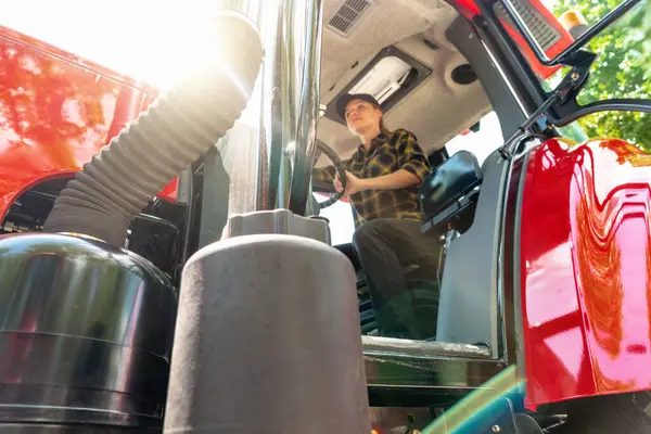 İçinde bulanık bir kadın sürücü olan bir çiftlik ya da inşaat traktörü..