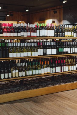 İçki dükkanının perakende vitrininde boş etiketli şarap şişeleri.