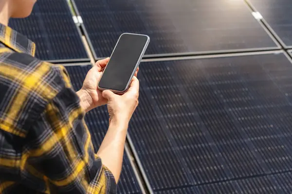 Güneş enerjisi santralindeki kadın mühendis, panelleri izlemek için kablosuz teknoloji kullanıyor.