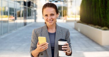 Bayan ofis çalışanı ofisin dışında kahve molası veriyor.