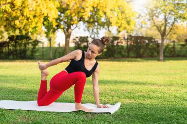 Yaz tatili parkında yoga antrenmanı yapan zinde bir kadın.