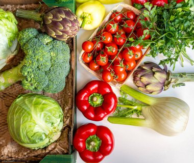 Beyaz masadaki taze organik sebzelerin hemen üstünde.