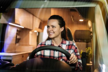 Karavanı kullanan neşeli genç kadın.