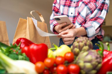 Market makbuzunda akıllı telefonlu QR kodunu tarayan kadın