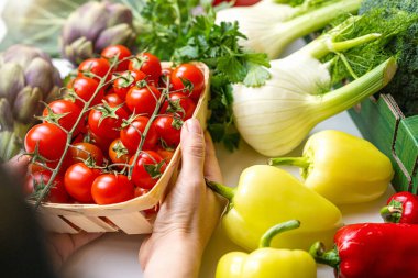 Tarladan masaya organik sebzeleri tutan eller.