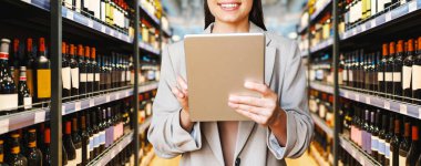 Şarap ve içki dükkanında dijital tablet kullanan iş kadını
