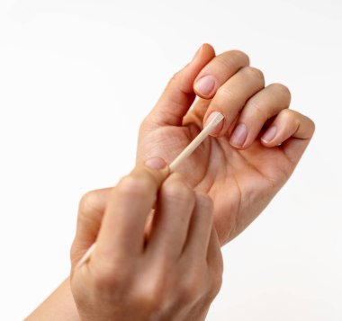 Evde tırnak törpüsü kullanan bir kadın. Tırnak etlerini geri itme