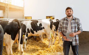 Çiftliğin içinde dijital tablet tutan erkek çiftçinin portresi.