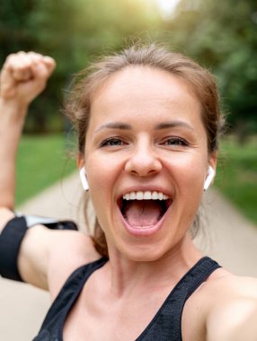 Heyecanlı bir kadın sokak çalışmasını tamamladıktan sonra kaslarını kasıyor ve selfie çekiyor.