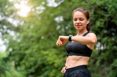 Sporcu açık hava antrenmanı sırasında akıllı hareket istatistiklerini kontrol ediyor
