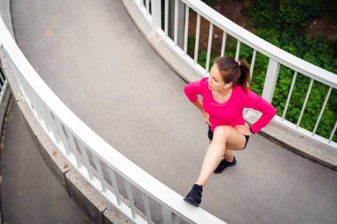 Kentsel yaya köprüsünde spor yapan sağlıklı bir kadının hava görüntüsü..