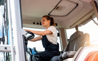 Kendine güvenen kadın tarım işçisi traktör çalışıyor..