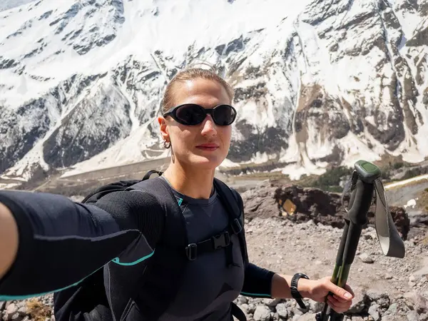 Dağlarda yürürken selfie çeken kendinden emin bir kadın.