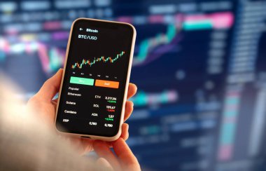 Akıllı telefondaki kripto para birimi eğilimlerini analiz eden kadın dijital yatırımcı.