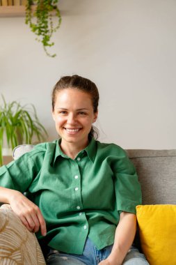 Evdeki yeşil tişörtlü genç bayanın samimi fotoğrafı.