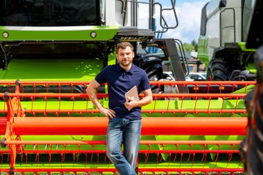 Erkek tarım uzmanı dijital tabletle birlikte açık hava ekipman bayiliğinde başlığı birleştirerek