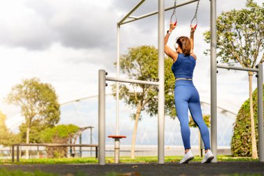 Açık hava fitness sahasında aktif bayan atlet eğitiminin arka görüntüsü