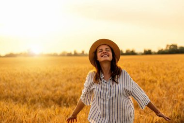 Hasır şapkalı mutlu genç kadın kırda hafta sonunun tadını çıkarıyor.