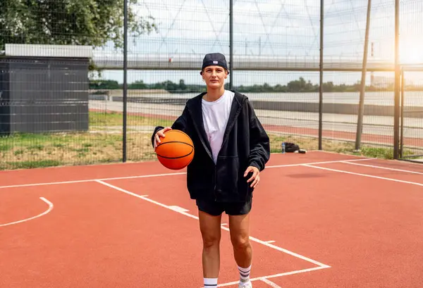 Sokak stili genç kadın sokak basketbolu oynuyor.