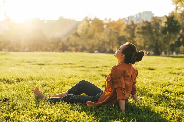 Doğada çıplak ayakla rahatlayan bir kadın.