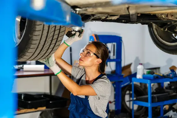 Otomobil tamirhanesinde çalışan kadın tamirci. 