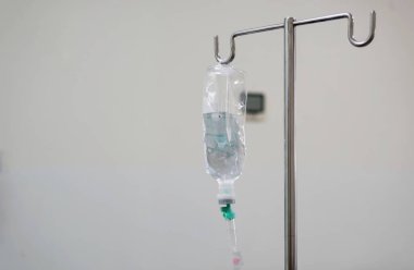 Hastane odasındaki metal bir direğe asılı serum torbası.