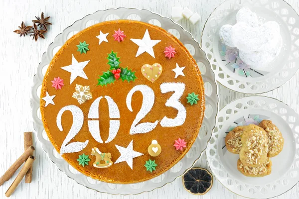 stock image Traditional Greek new year's cake for 2023, known as vasilopita and greek christmas desserts, melomakarona and kourabiedes