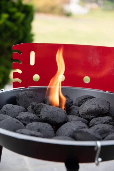 stock image a man lights a fire with a lighter special charcoals for a barbecue a barbecue house on the terrace prepares a place for a barbecue. High quality photo