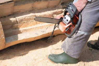 Elektrikli testere. Elektrikli testerenin zinciri ahşap bir kütüğü testereyle keserken düştü, alet kırıldı, alet iş yerinde kırıktı.