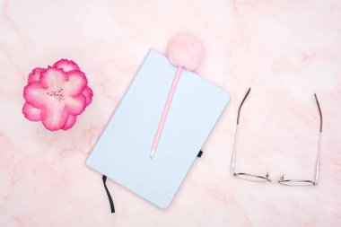 Pembe masasında kalem olan mavi not defteri, bir kız öğrencinin çalışma yeri. Yüksek kalite fotoğraf