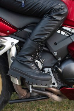 Honda motorsikletinin basamaklarında güzel siyah bir botla yürüyen kızlar. Yüksek kalite fotoğraf