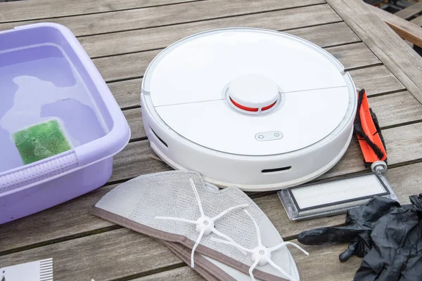 woman washing a trash can in a robot vacuum cleaner,planned maintenance of equipment for long-term use, High quality photo