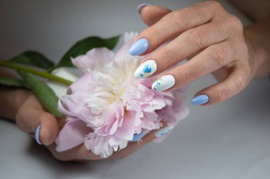 girl with a beautiful white blue manicure with a bouquet of delicate peonies, . High quality photo