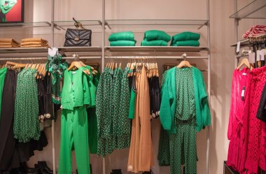 Mağazadaki farklı modeller yeşil ve kırmızı bluzlar, moda kıyafetlerinin parlak yaz renkleri, yüksek kaliteli fotoğraflar.